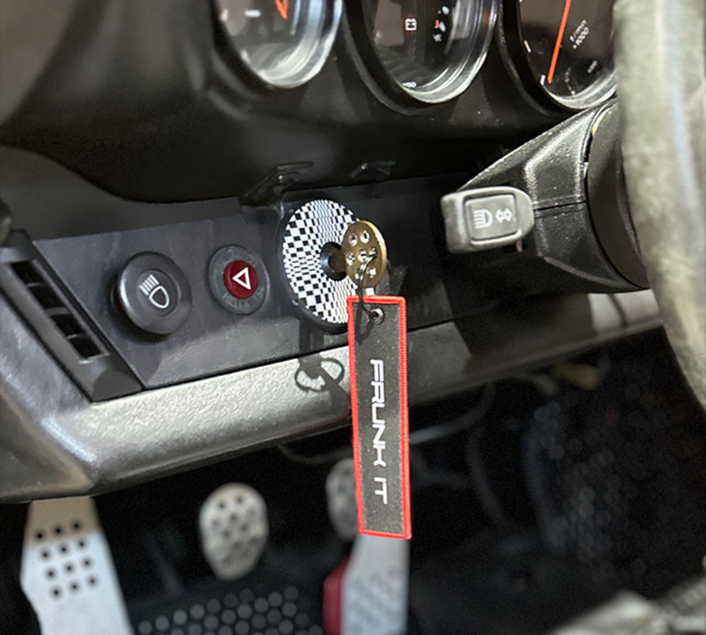 The Frunk Club embroidered key tag with red border and silver lettering, attached to car keys.