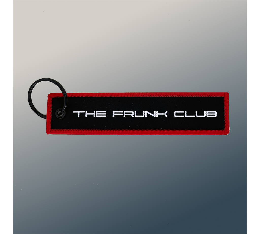 The Frunk Club embroidered key tag with red border and silver lettering, attached to a keyring.