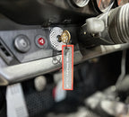 The Frunk Club embroidered key tag with red border and silver lettering, attached to car keys.