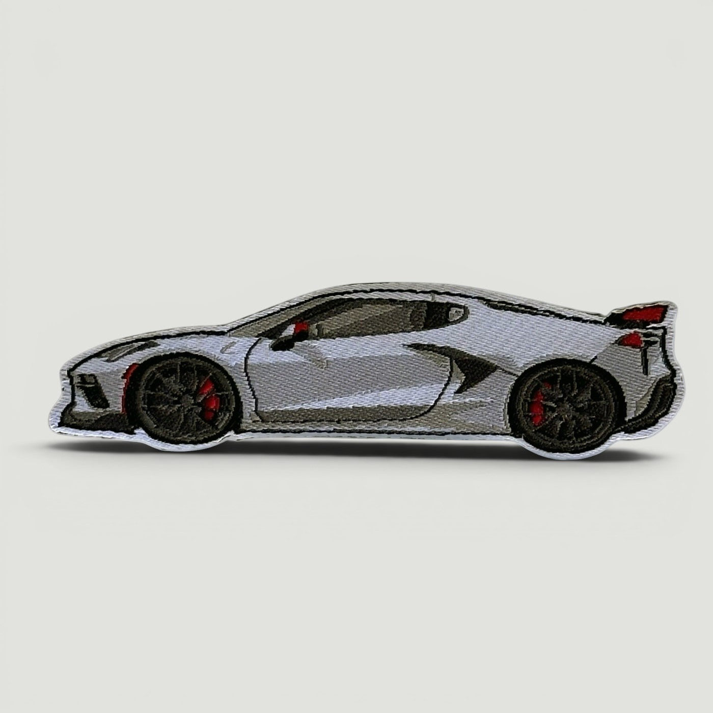 The Frunk Club silver sports car embroidered patch with black wheels and red brake calipers.