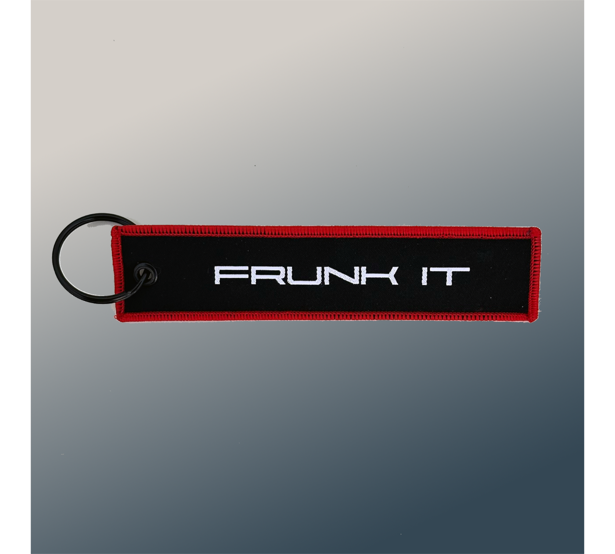 The Frunk Club black embroidered key tag with red border and silver 'FRUNK IT' lettering.