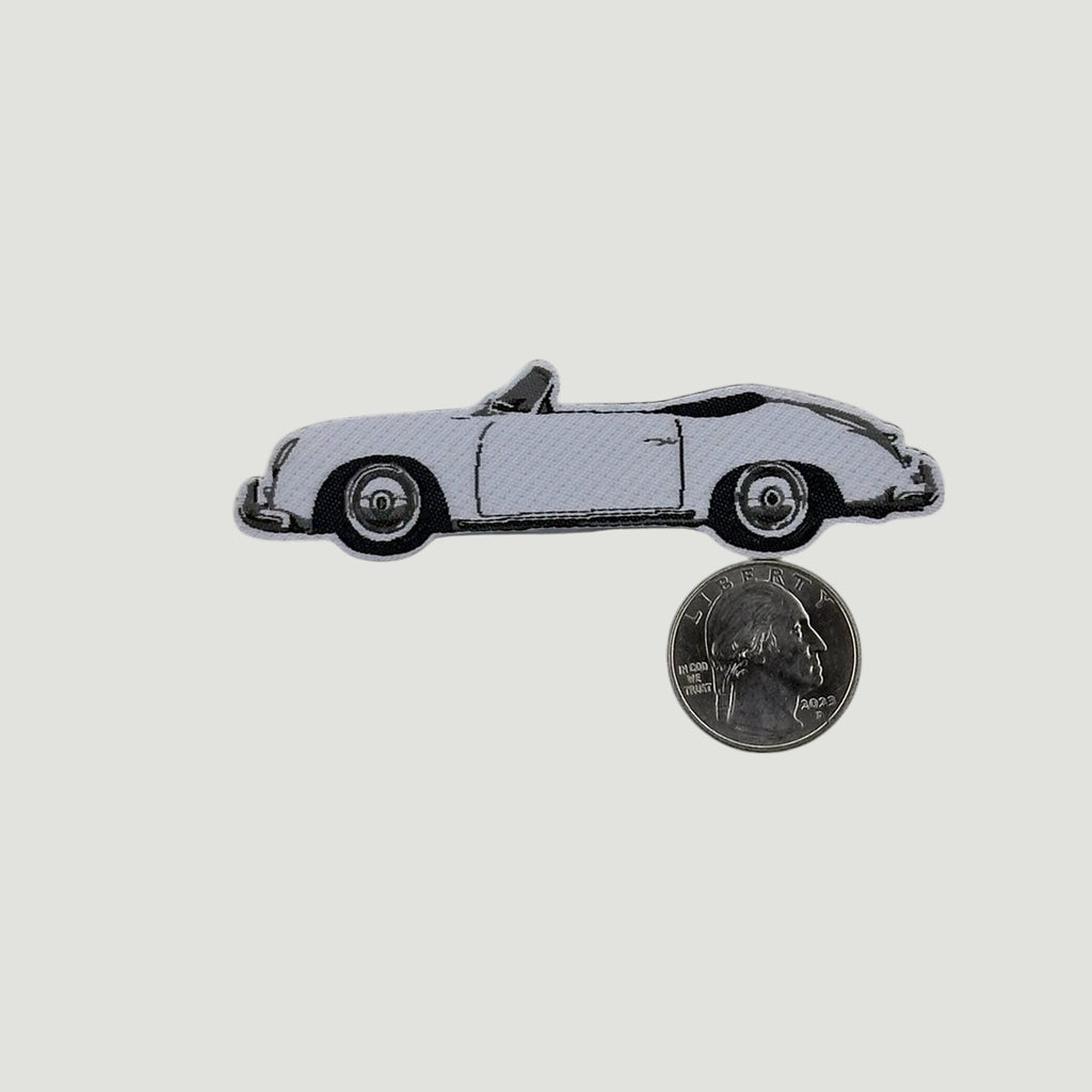 The Frunk Club woven patch featuring a white convertible 356 car silhouette with black trim. Includes a quarter for scale.